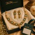 Elephant motif kundan necklace set with green stones - full set view on dark green background