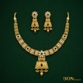 Close-up of antique gold kundan pendant with ruby stone and engraved scrollwork