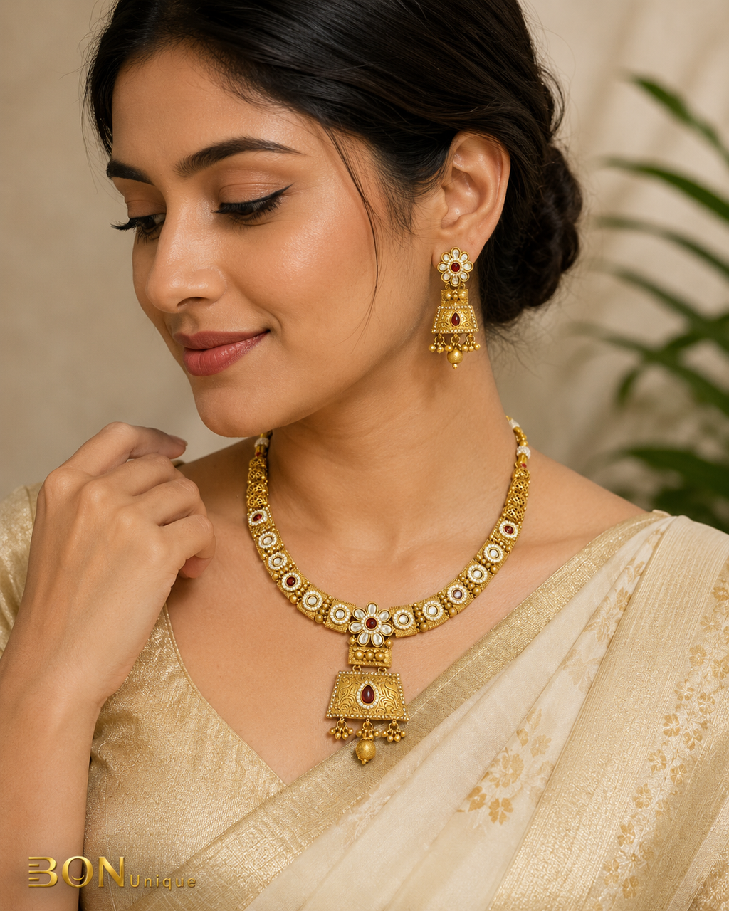 Model wearing antique gold kundan necklace set with ruby stones and jhumka earrings on ivory saree