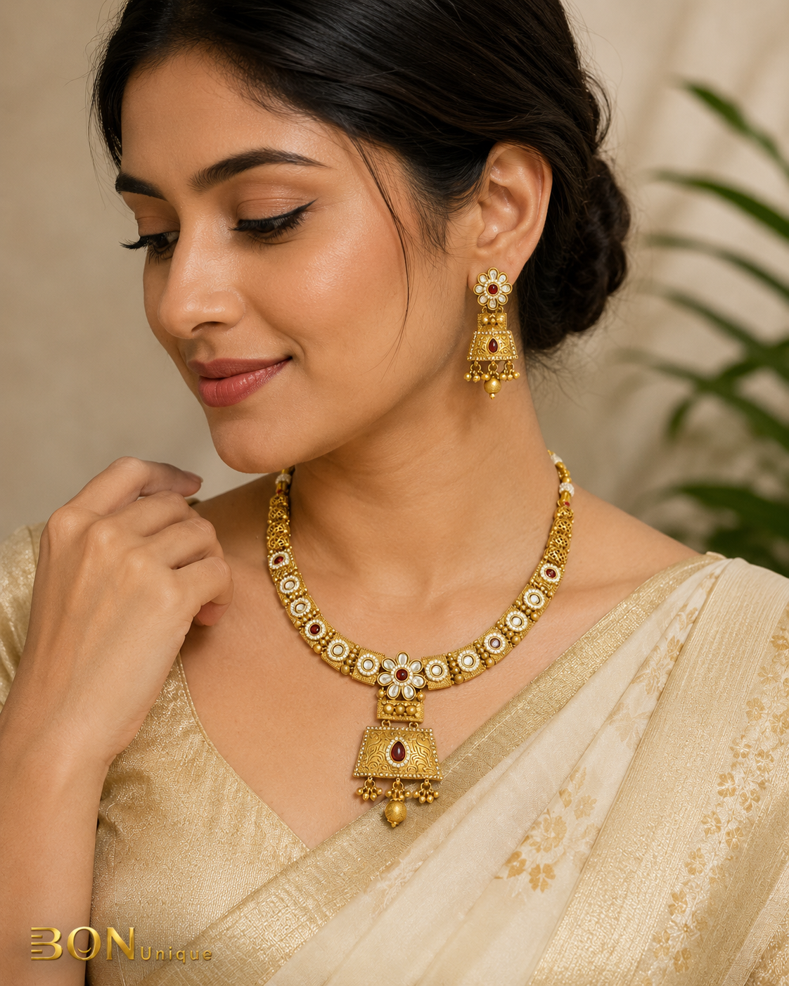 Model wearing antique gold kundan necklace set with ruby stones and jhumka earrings on ivory saree