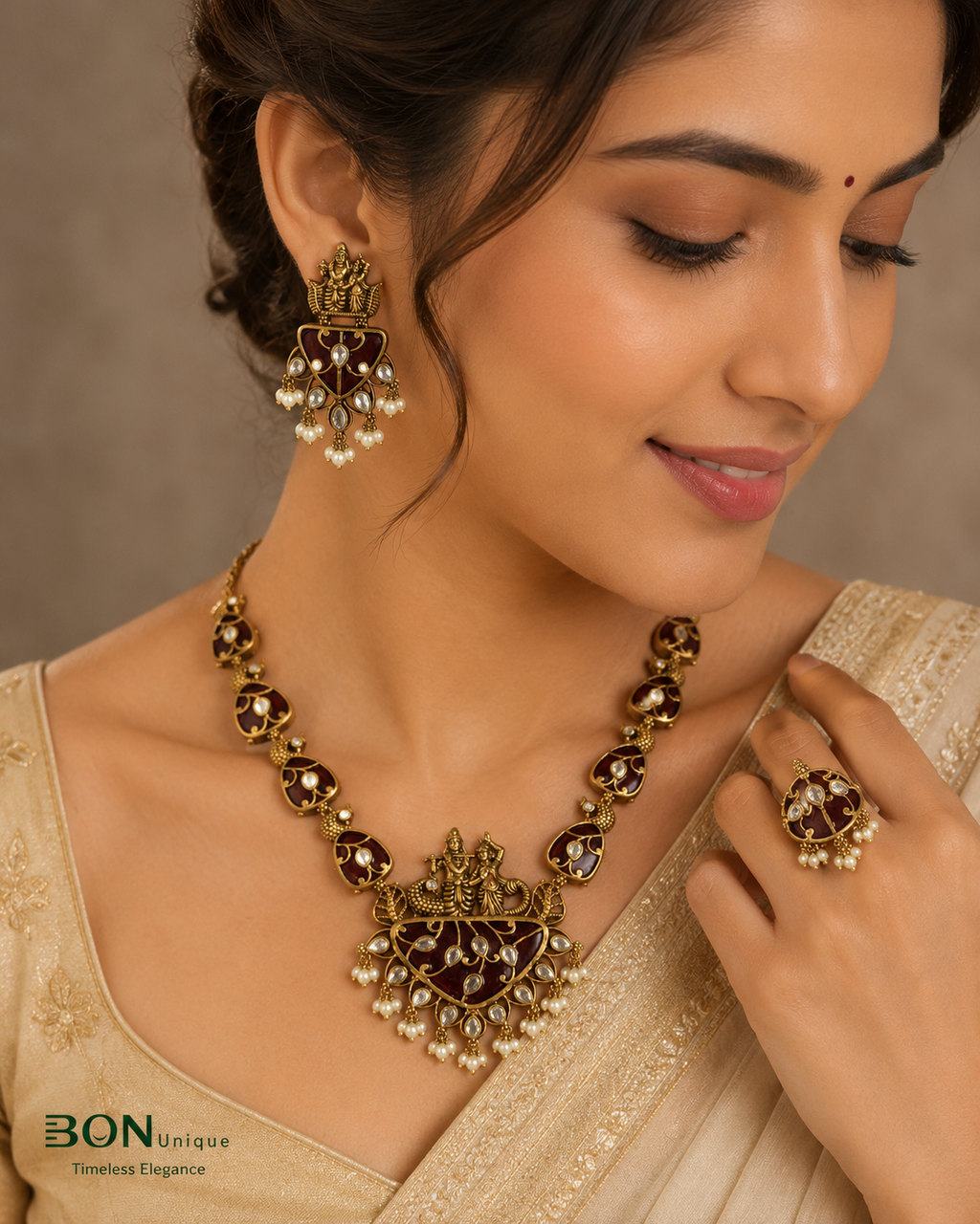 Model wearing antique gold Radha-Krishna temple necklace set with maroon enamel and pearl drops on ivory saree