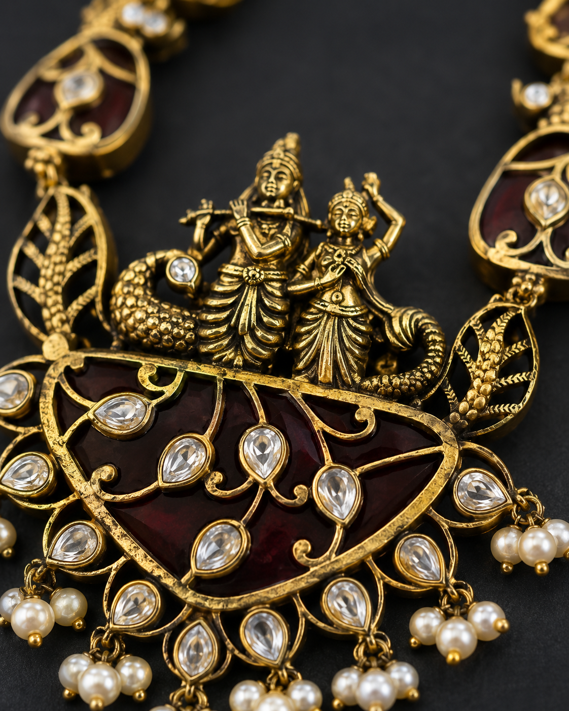 Close-up of Radha-Krishna pendant with maroon enamel, polki stones and cascading pearl drops