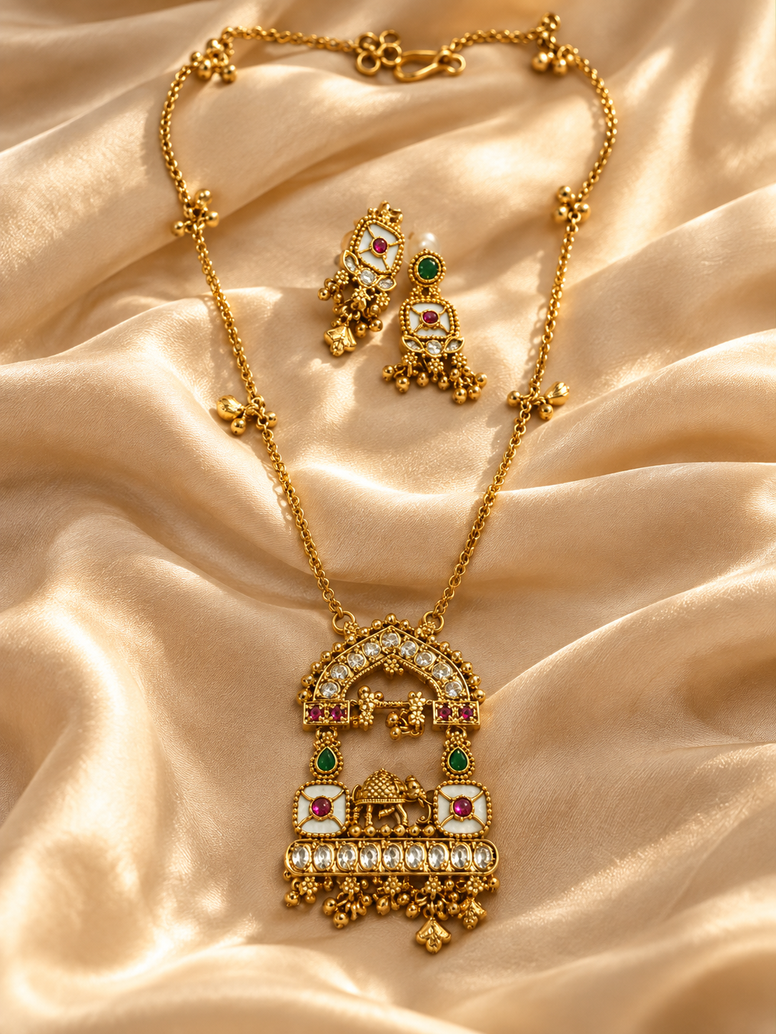 Traditional necklace and matching earrings displayed on satin fabric
